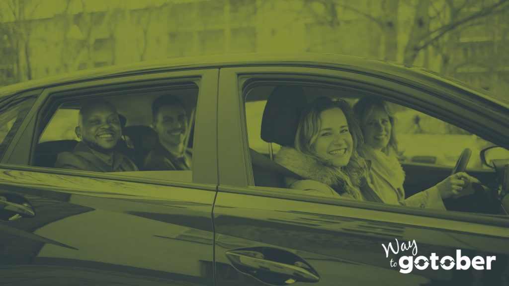 A middle-aged white woman with shoulder-length light-colored hair drives a carpool of diverse passengers of various races and genders; paired with the words Way to Go-Tober.